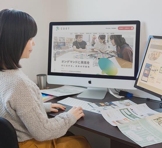 デスクの画面でWebサイトのデザインを確認している様子